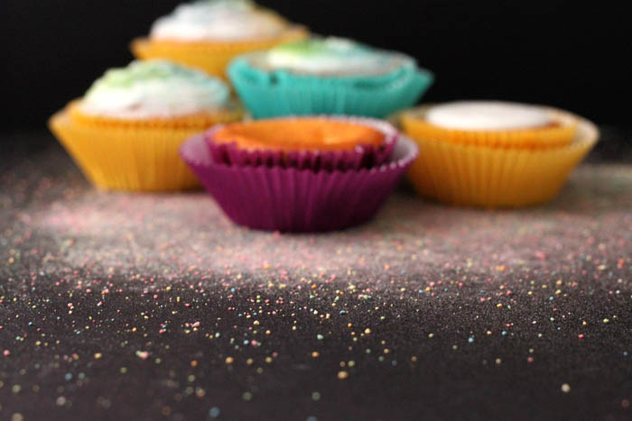 a small group of different colored cup cakes