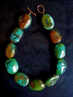 a necklace made with green and brown stones