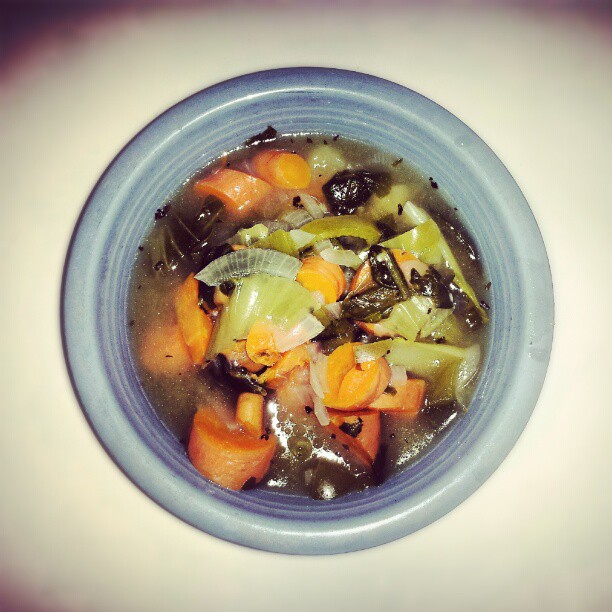 a bowl filled with soup and vegetables on top of a table