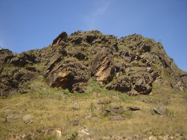 some rocky hillside with grass and plants