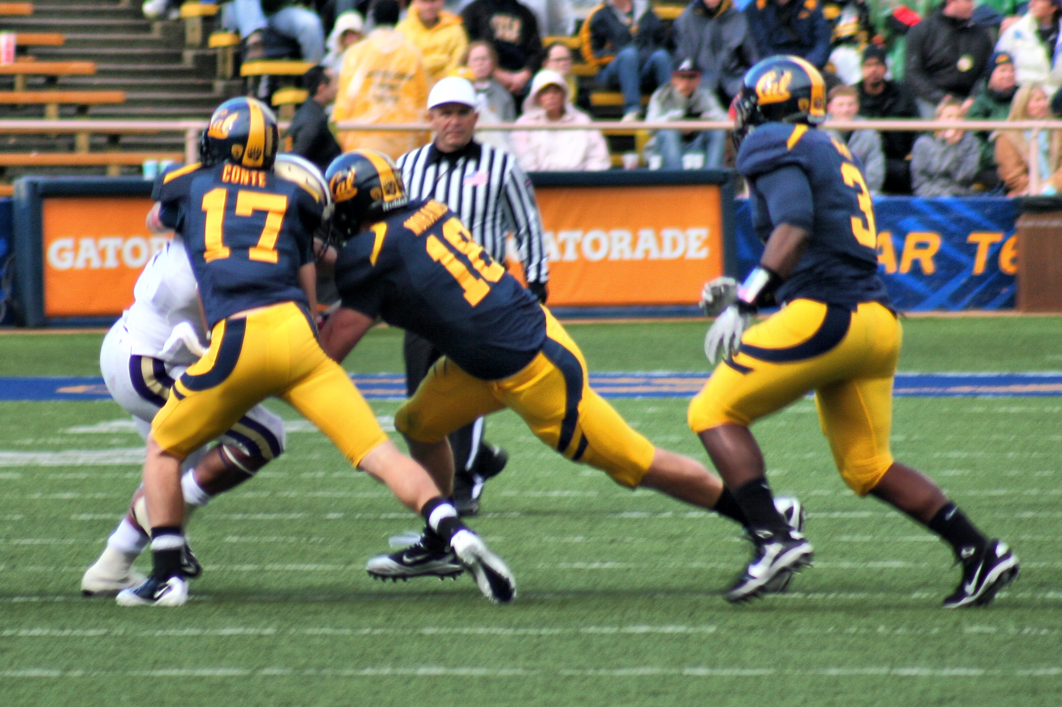 two football players in uniforms playing against each other on a field