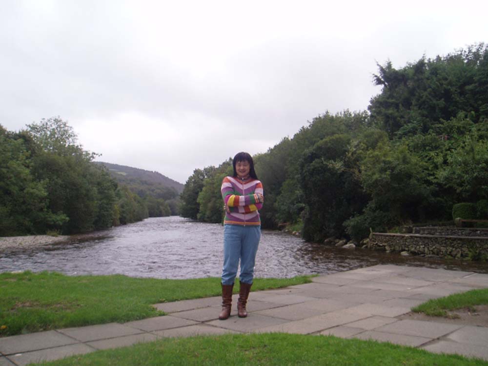 a girl poses by a river while looking at the camera