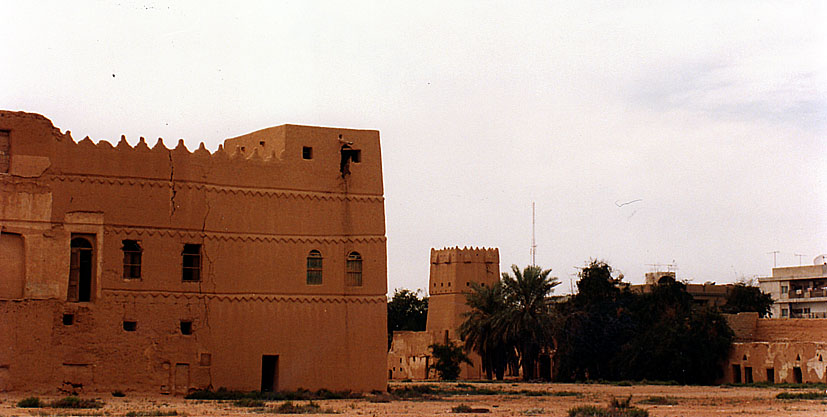 a desert city is surrounded by tall adobe style buildings