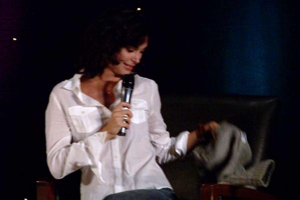 a woman is holding a microphone while sitting in a chair