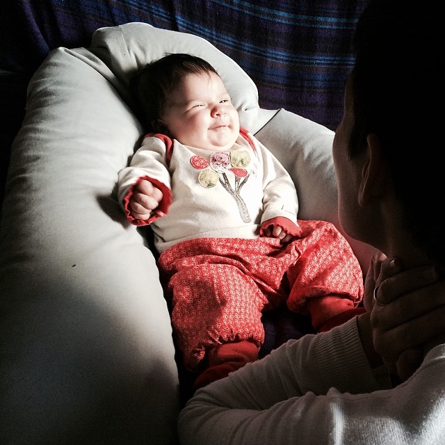 a baby in a white shirt sitting on a bean bag chair