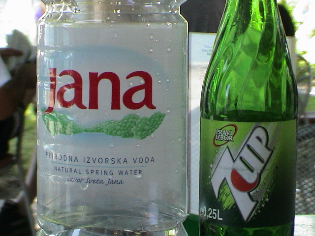 a bottle of jaana water next to the top of a bottle of spring water