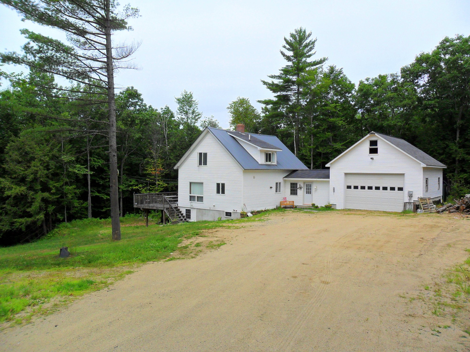 two white houses sitting next to a dirt road