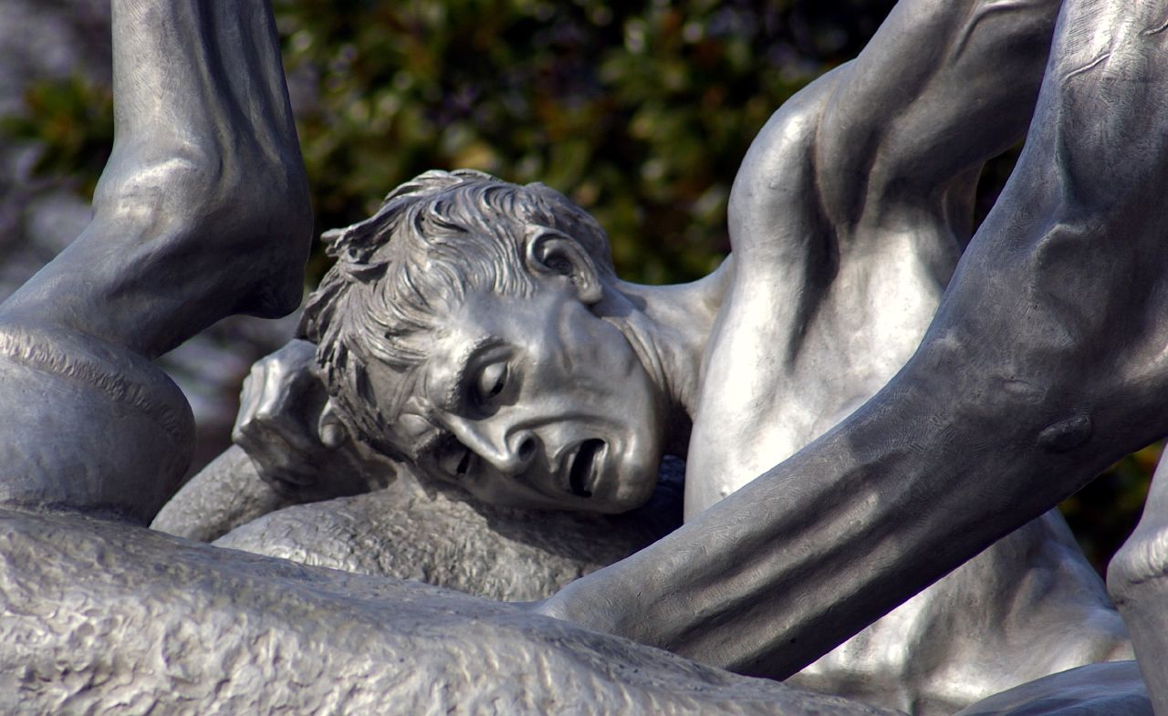 a statue of a boy playing on his belly