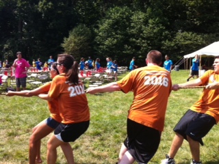 a man playing tug - balls with two woman on his knee