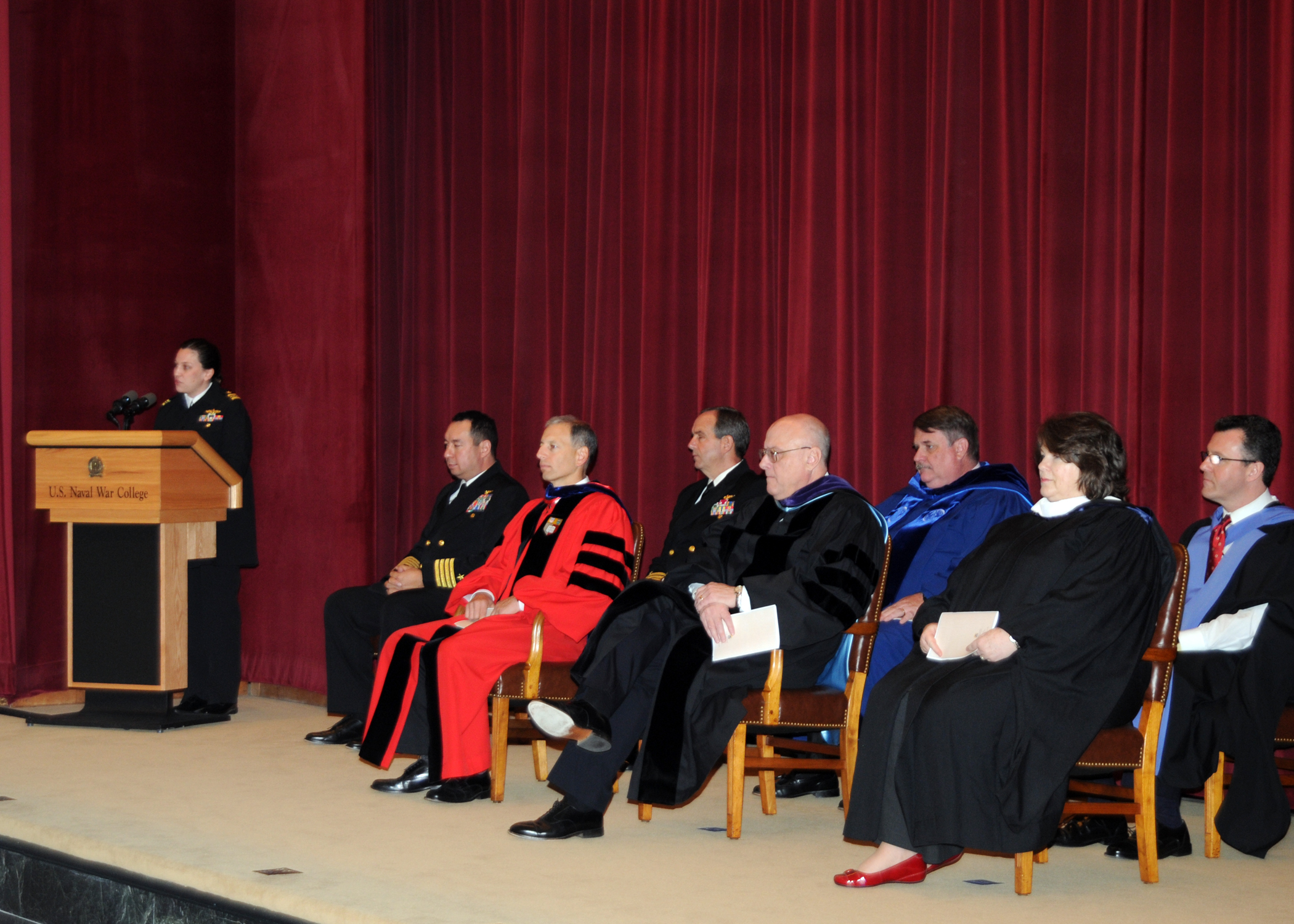 there is a person in a priest's robes speaking at a podium