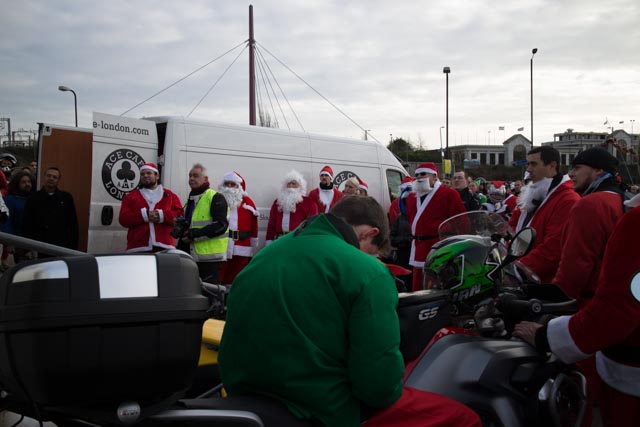 a bunch of people wearing santa claus outfits on a motorcycle