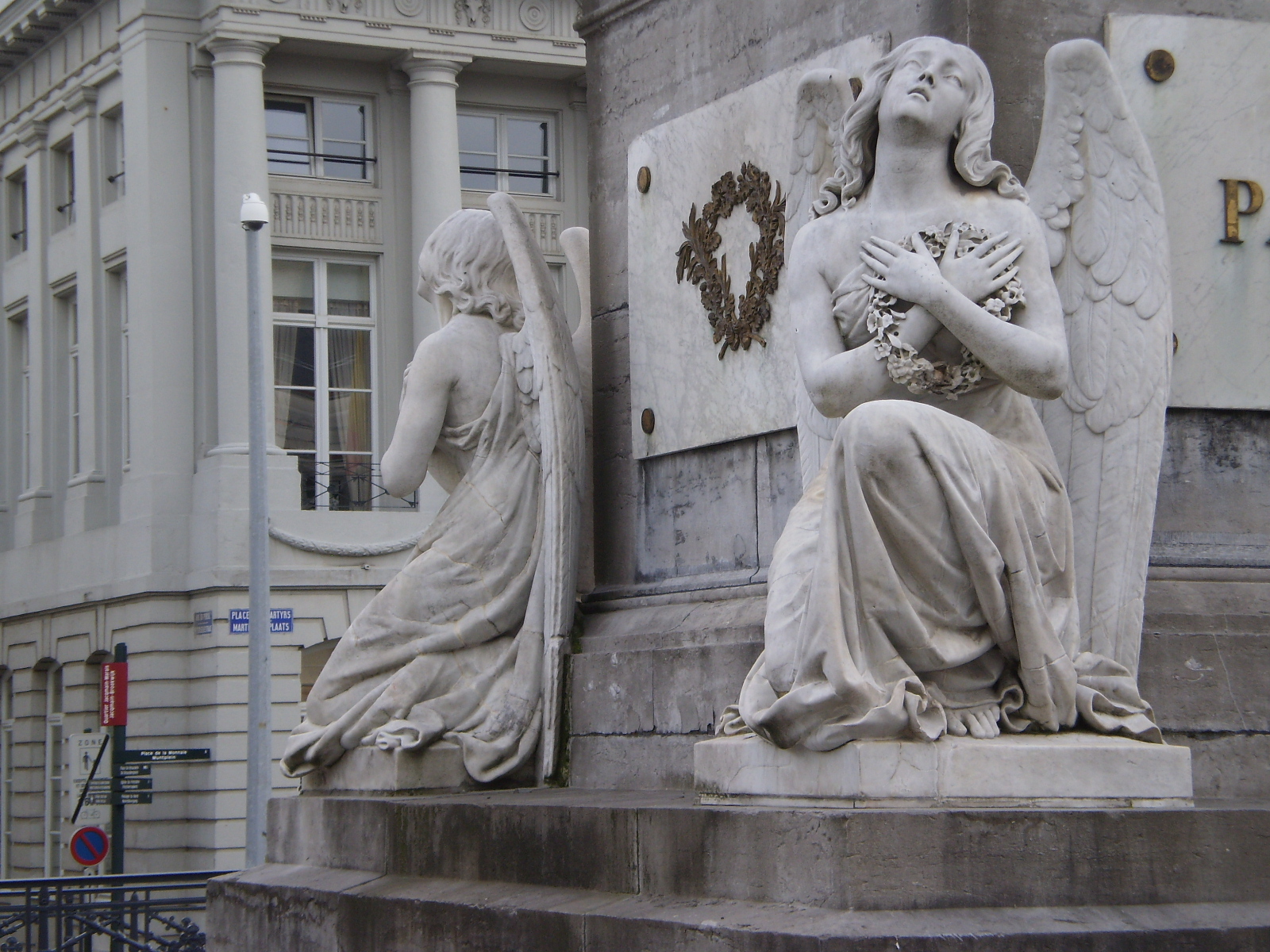 two statues sitting on some stone steps next to a building