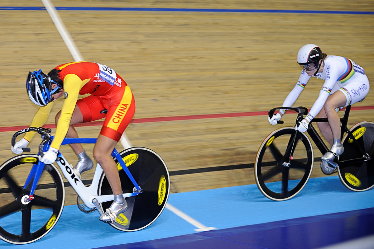 two men riding bicyclists on the same track in a race