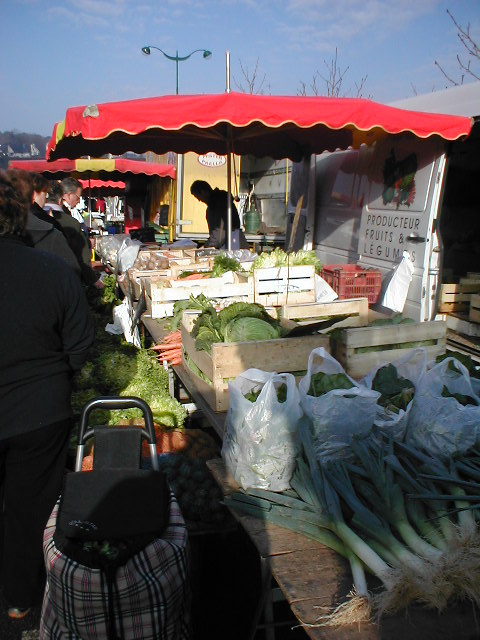 a farmers market with a dog in it and vegetables for sale