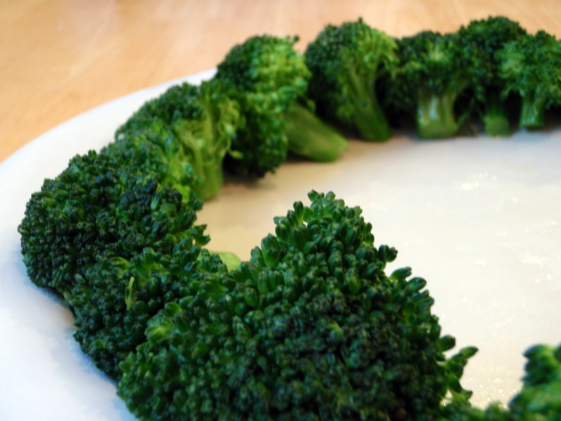 a close up of a plate of broccoli on a wooden table