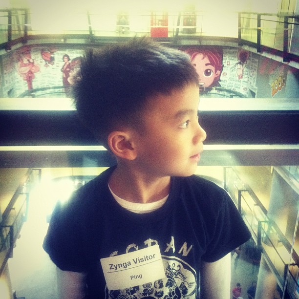 the young child stands by a window looking into an elevator