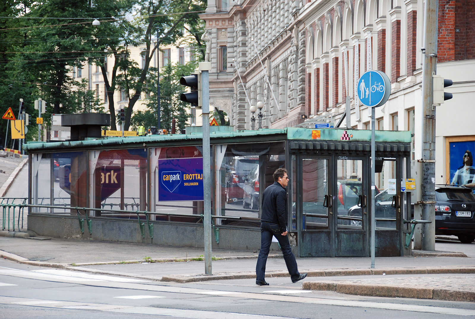 a man is walking down the street near a bus stop