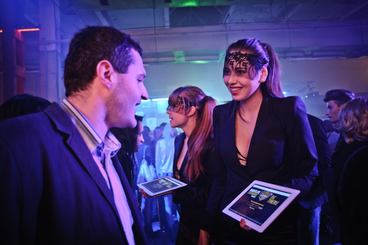 two women and a man hold their ipads in the dark