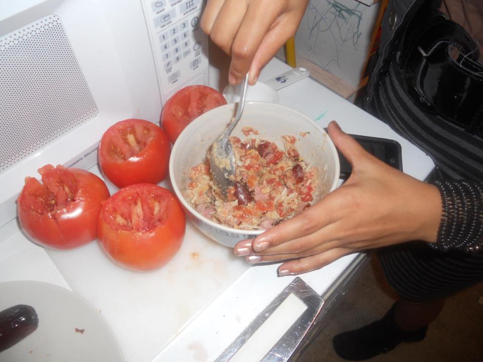 two hands picking up some red peppers out of the oven