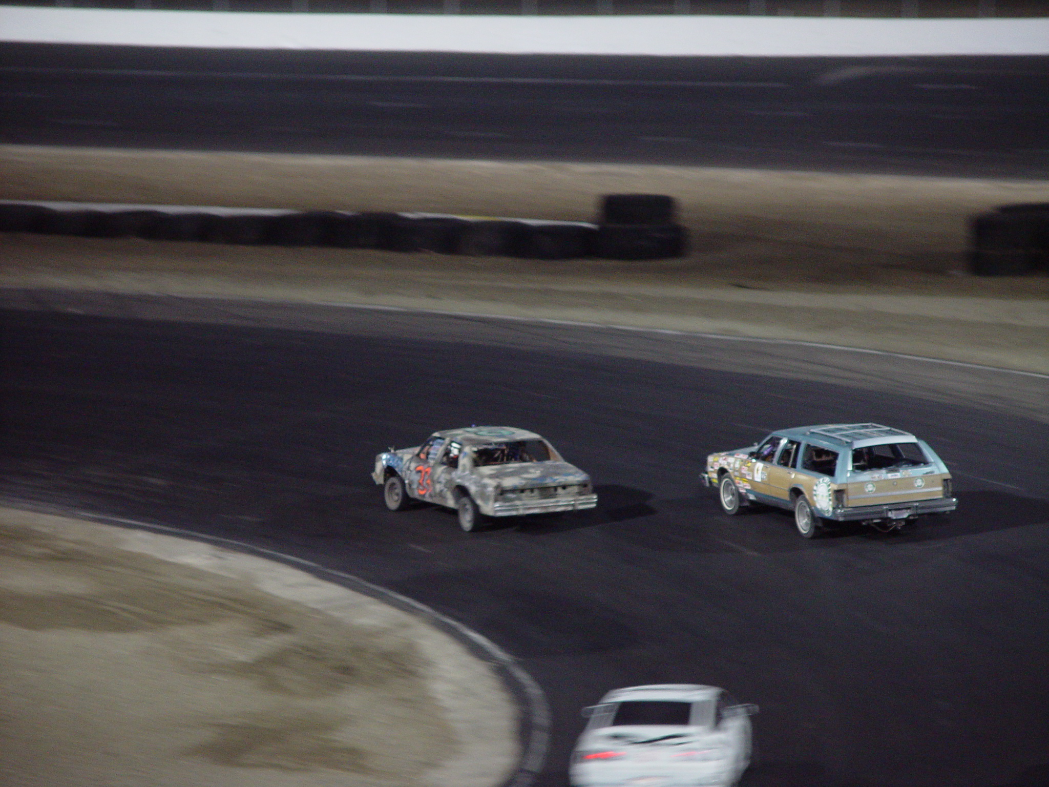 two cars that are racing together on a track