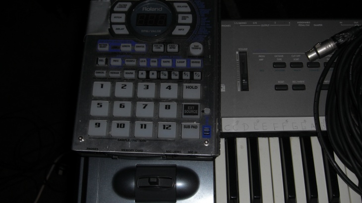 an electronic keyboard is next to two other electronic devices
