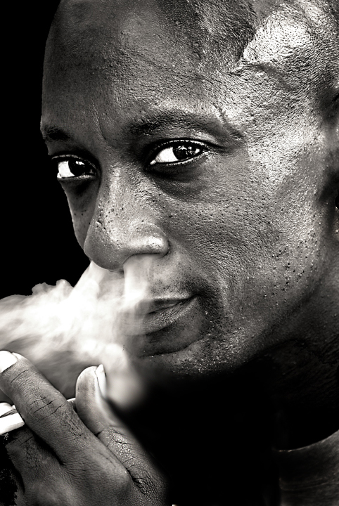 a man is smoking a cigarette and posing