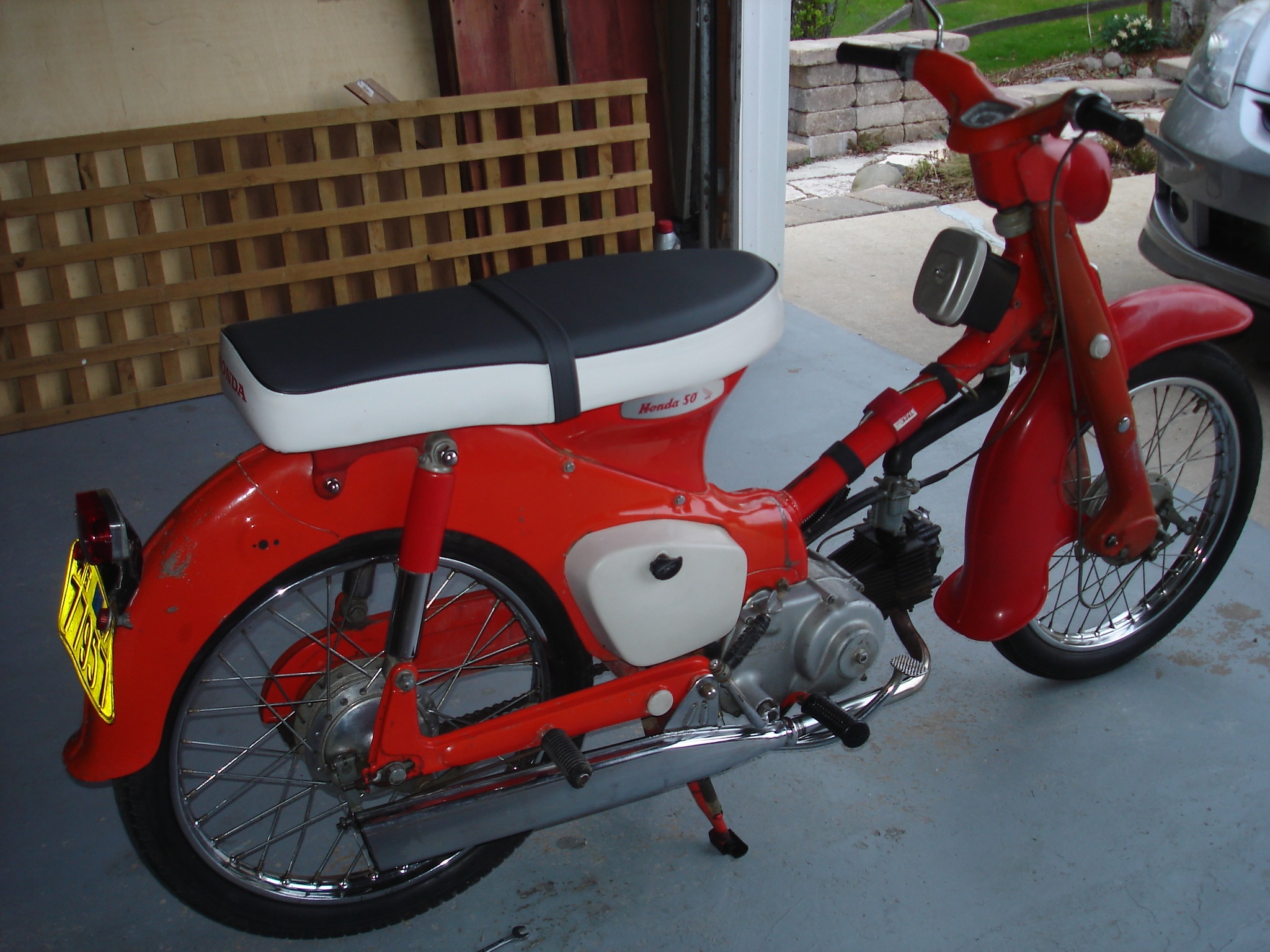 the red motorcycle is parked in a garage