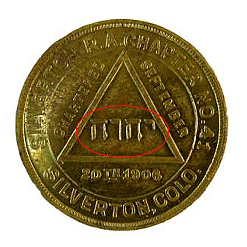 an old coin is featured with a red triangle