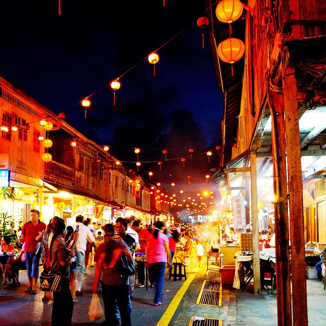 a city sidewalk with various people shopping and dining