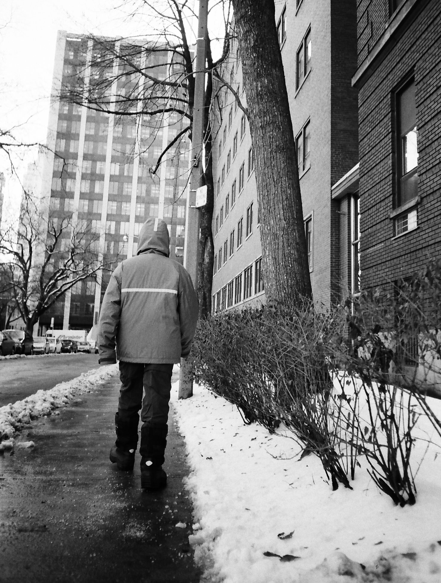 a man is walking down the sidewalk in winter