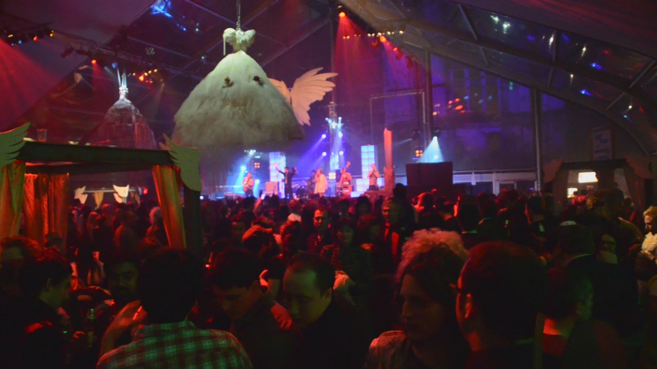 crowd of people in front of a decorated bird over head in an indoor concert hall