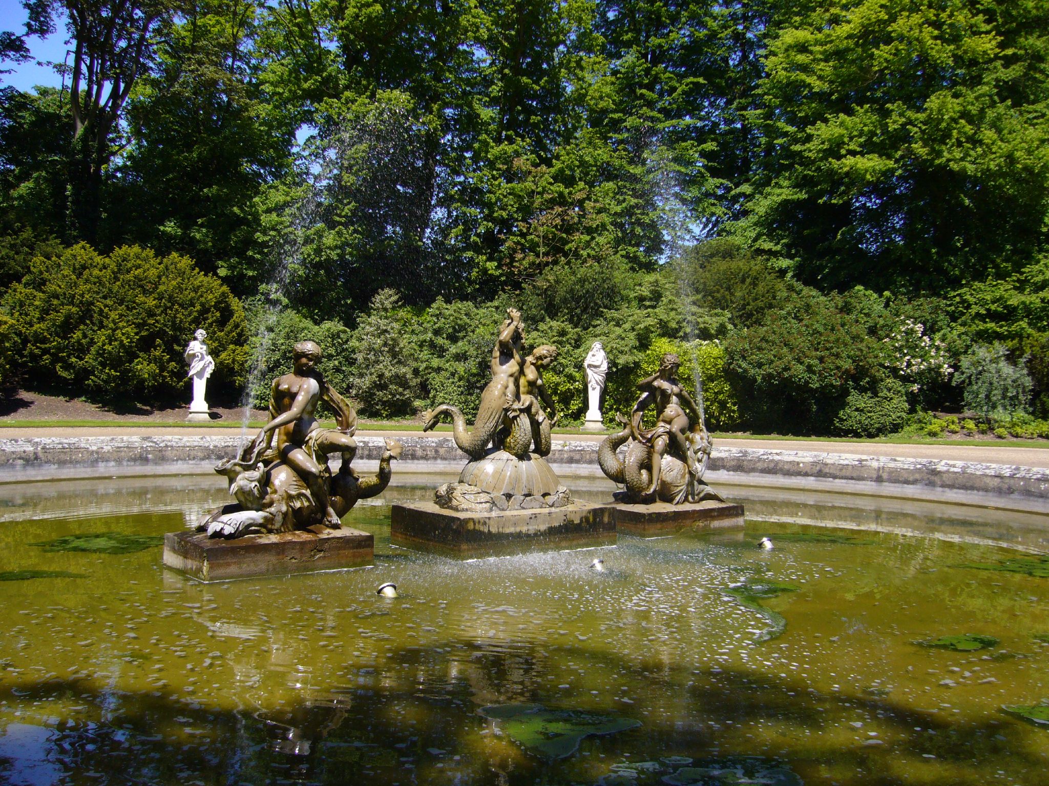 a stone fountain with three statues sitting on it