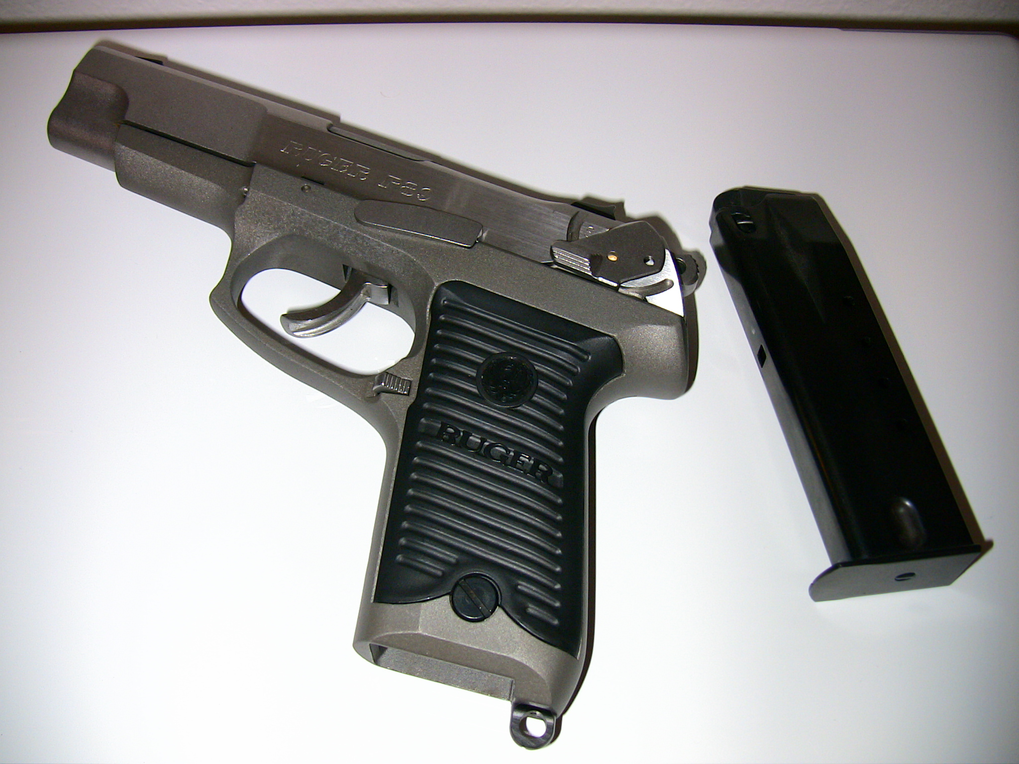 the pistol sits next to a smaller black object