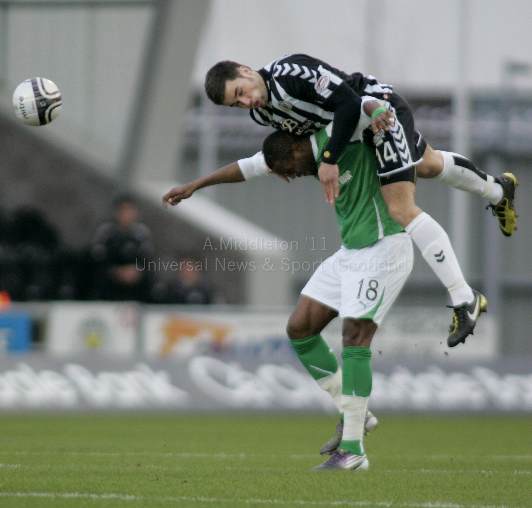 two soccer players jump for the ball during a match