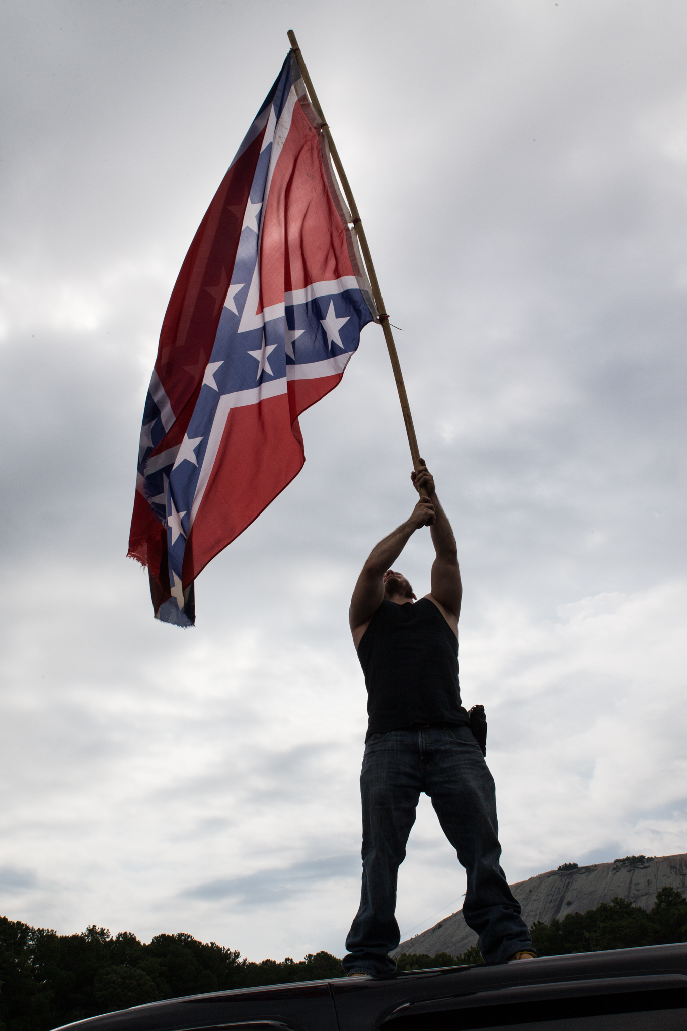 there is a man raising the flag on a car