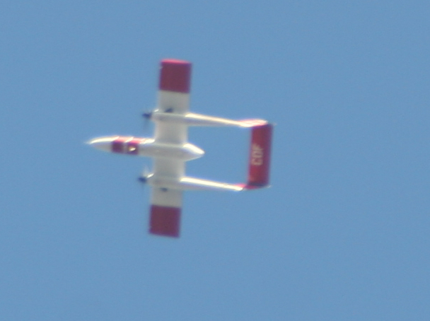 a red and white plane flying in the sky