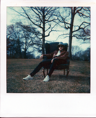 a person sitting on a park bench next to a tree