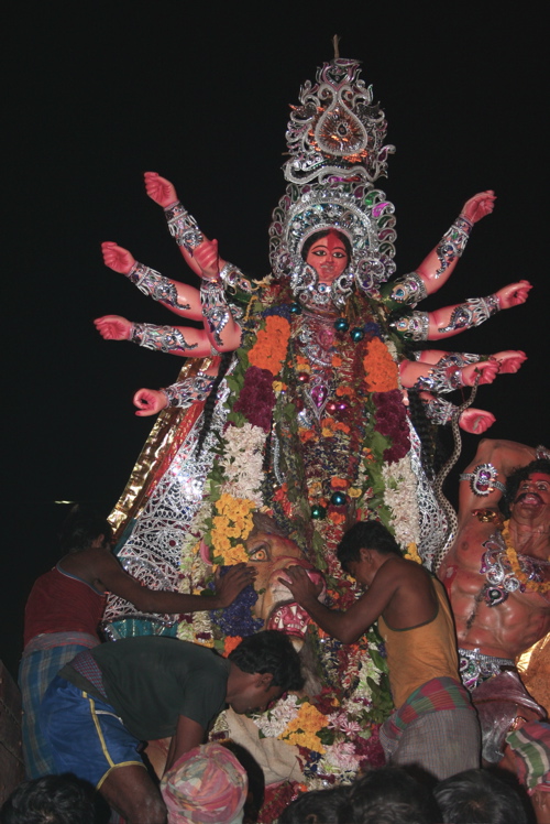 group of men gathered around a large statue of hindu god