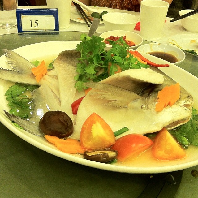 some fish and vegetables on a plate with wine
