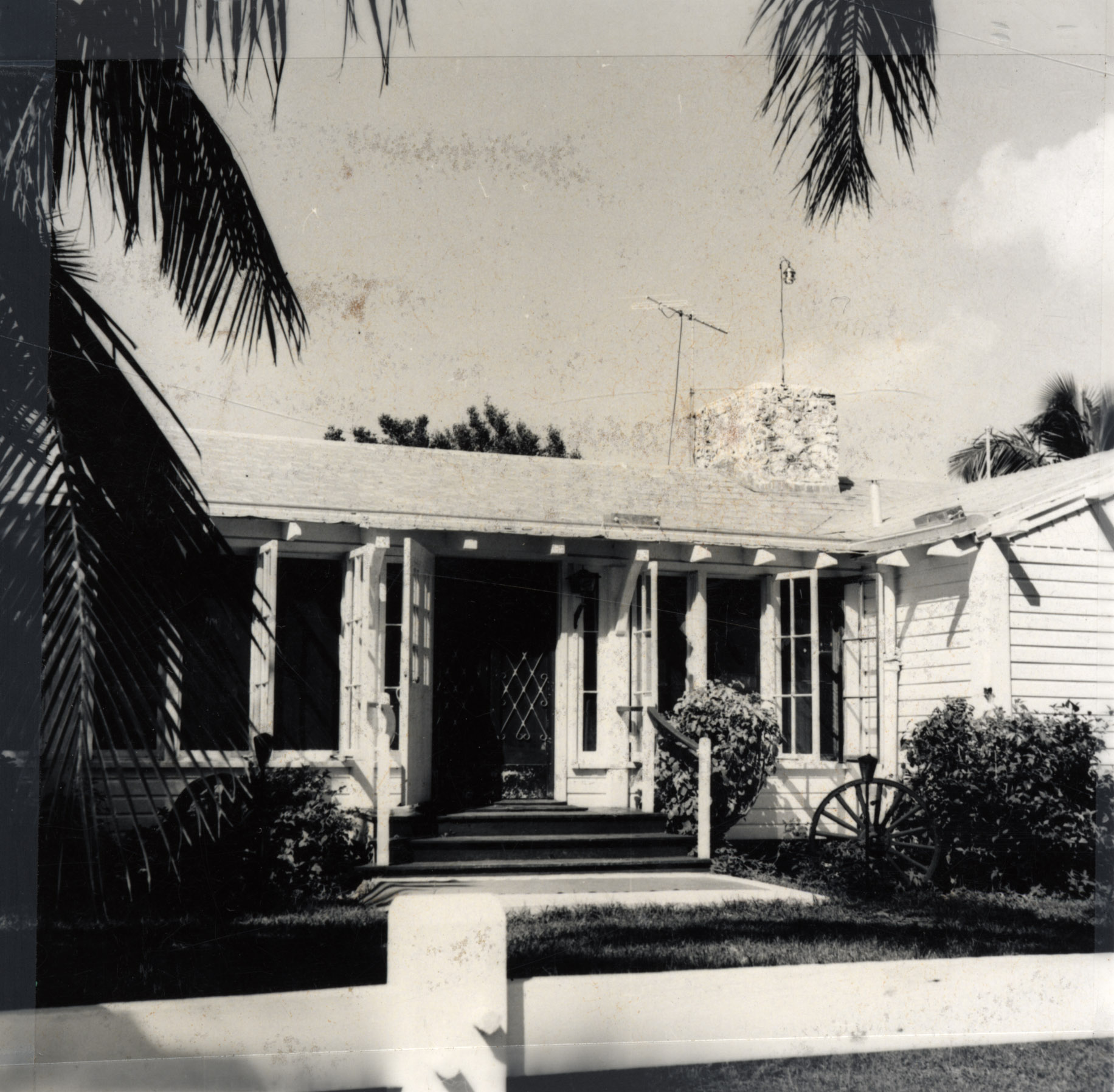 an old house with palm trees in the front yard