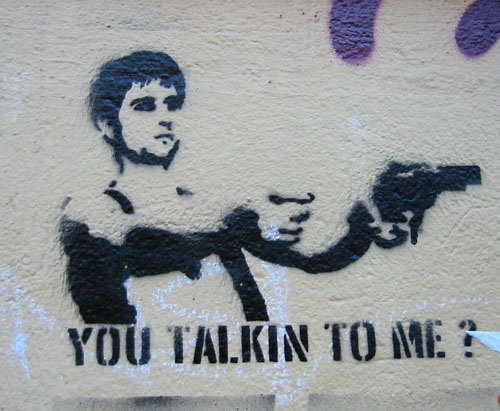 graffiti depicting a man with a gun holding another person's hand