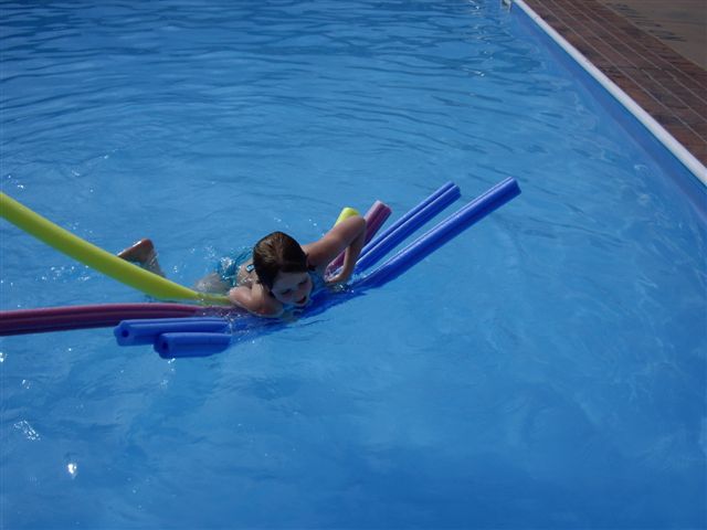 child floating on inflatable pool toys
