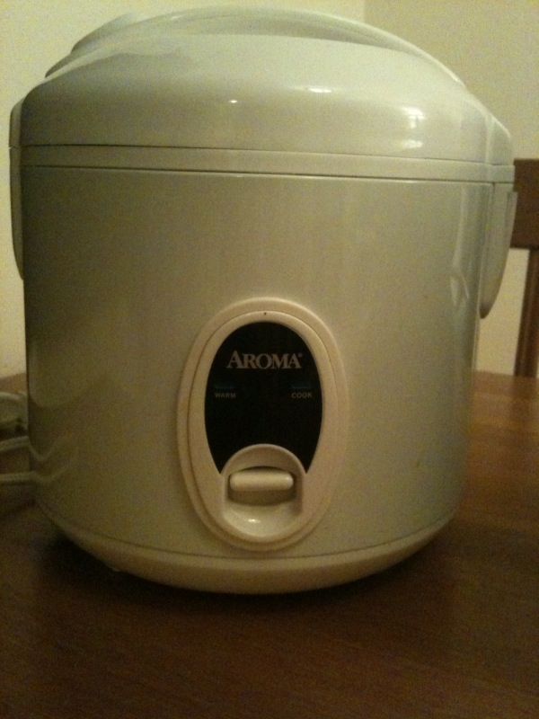 an aroma rice cooker sitting on a table with the lid open