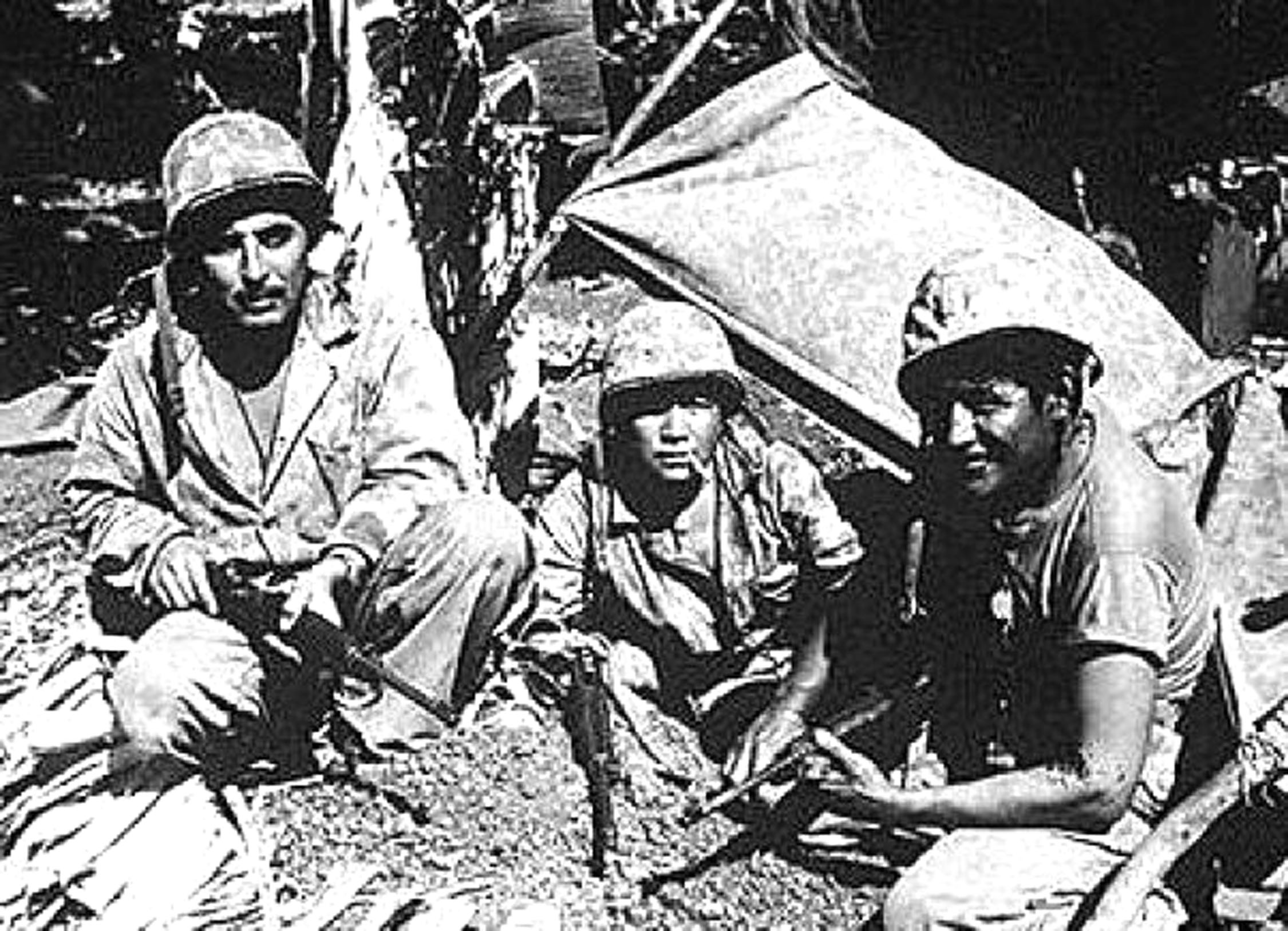 soldiers sitting in a line with some kind of shelter