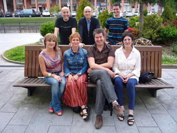 a group of people sitting on a park bench next to each other