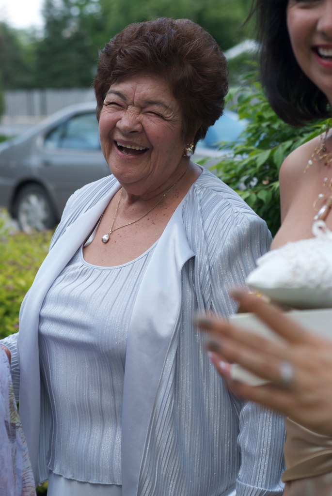 two women wearing white smiles together