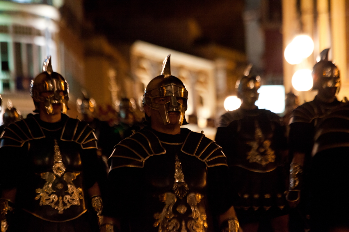 men dressed in gladiage are walking down the street