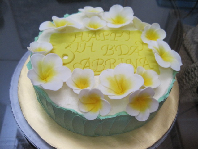 cake with yellow and white icing decorated with flowers