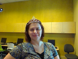 a woman with a tiara on sitting in a chair