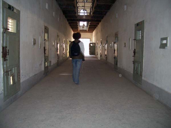 a woman walking down a dark hallway with multiple doors